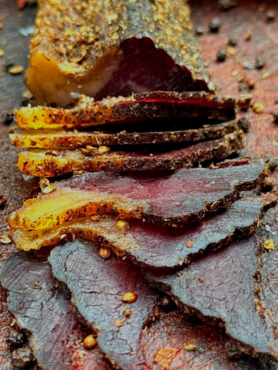 Biltong pieces Slices of cured meat arranged in a wooden bowl.